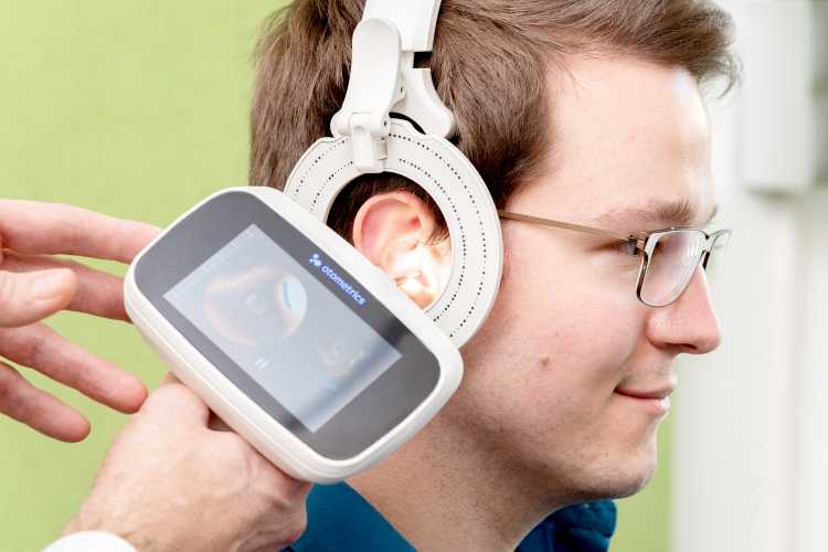 Das Ohr einer Person wird mit einem speziellen Scanner fotografiert.